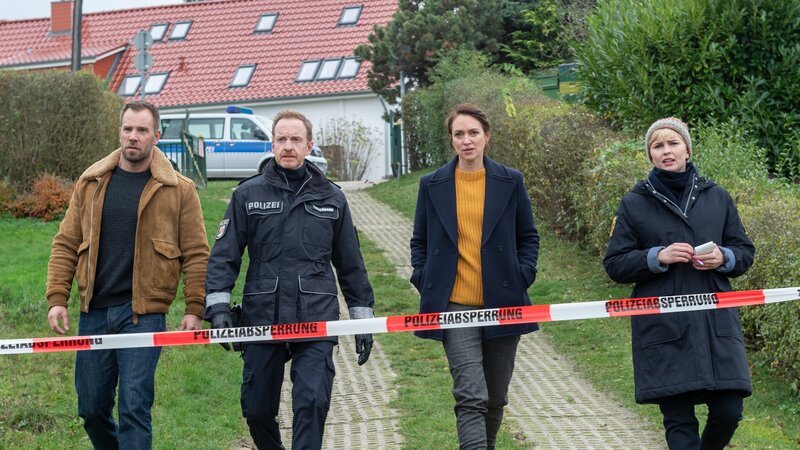 Kommissar Lars Pöhlmann (Dominic Boeer, l.), Polizeihauptmeister Kai Timmermann (Mathias Junge, 2.v.l.), Kommissarin Karoline Joost (Nike Fuhrmann, 2.v.r.) und Austauschpolizistin Stine Bergendal (Sidsel Hindhede, r.) vermuten Fremdeinwirkung bei der Tat. Die Patronenhülse ist verschwunden. Hat sie der Täter etwa beseitigt? Doch wer hat einen Grund, Jäger Hubertus Voss zu ermorden? – Bild: ZDF /​ Meyerbroeker