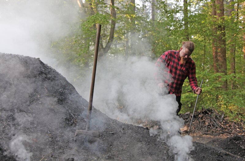 Köhler Max Geiselhart reguliert die Luftzufuhr im Kohlenmeiler – Bild: SWR