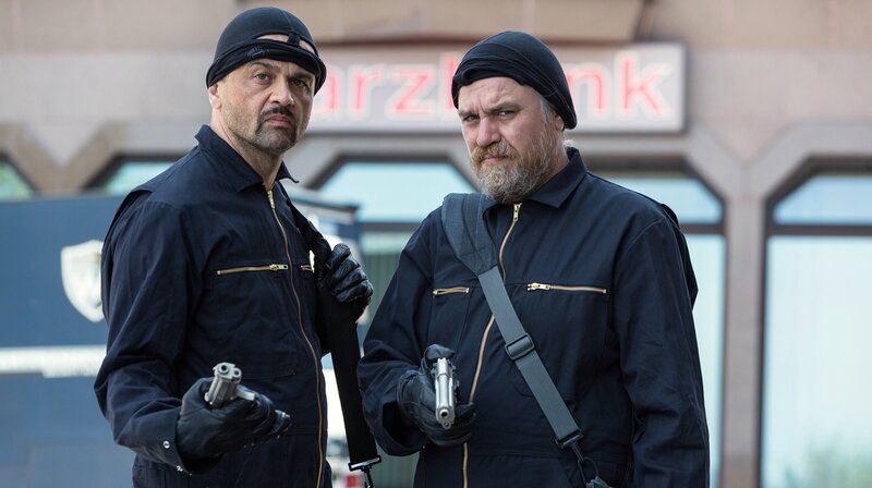 Verkehrte Welt in St. Andreasberg: Dorfsheriff Frank Koops (Aljoscha Stadelmann, re.) und der Gangster Hagen (Michael Rotschopf) planen die Harzbank auszuräumen. – Bild: ARD Degeto/​Kai Schulz