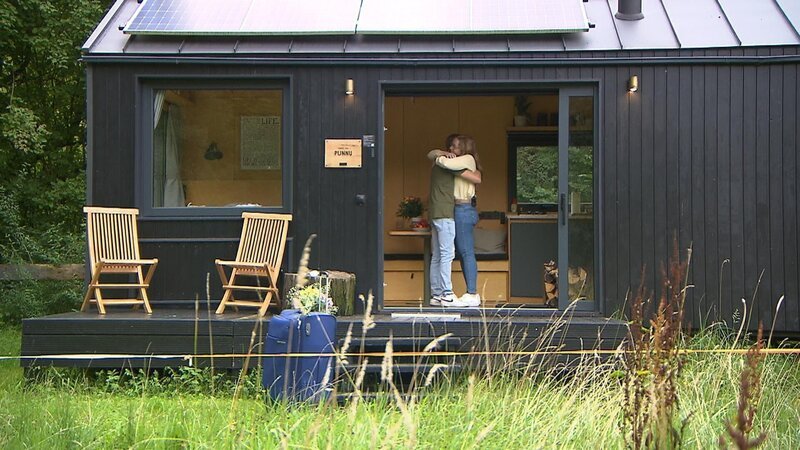 Christopher und Pauline umarmen sich vor dem TinyHouse, in dem die 25-Jährige während der Hofwoche übernachten wird. – Bild: RTL /​ Folge 21_003