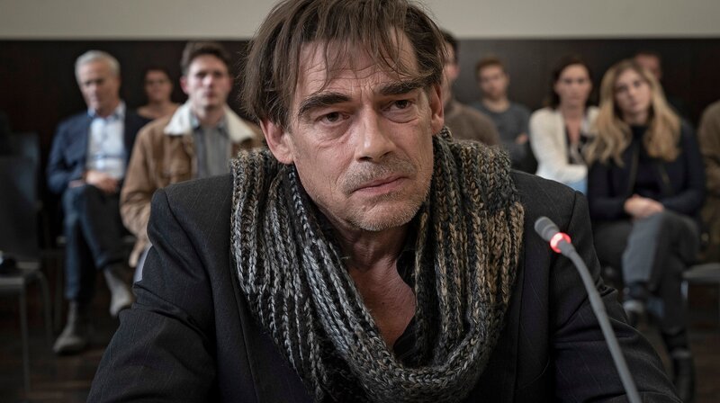 Ole Stark (Martin Feifel) sagt vor Gericht aus, dass er der wahre Schuldige ist. Für den Mord wurde vor vier Jahren sein Freund Moritz verurteilt. Kommissar Max Ballauf (Klaus J. Behrendt, l) ist unter den Zuhörer:innen. – Bild: WDR/​Bavaria Fiction GmbH/​Thomas Kost