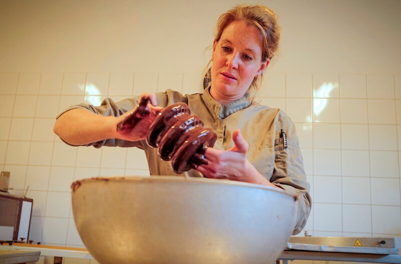Konditormeisterin Linn Middelberg beim Überziehen von Baumkuchen mit feinster Schokolade. – Bild: NDR