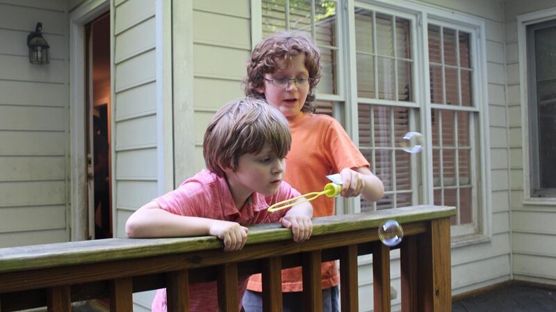 Hemphill family sons blow bubbles on the back porch in family package segment in episode 209, as seen on HGTV’s House Hunters Family – Bild: 2018, Scripps Networks, LLC. All Rights Reserved.