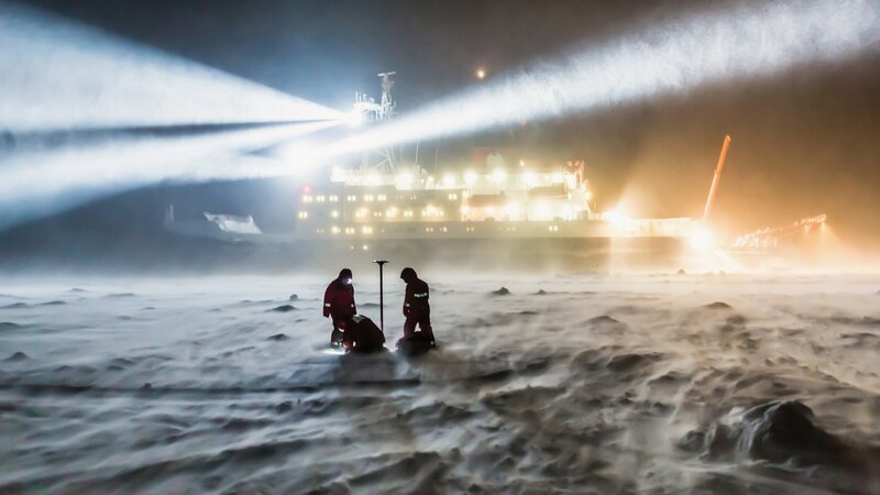 Arctic Drift – Ein Jahr auf dünnem Eis. AWI-Meereisphysikers arbeiten auch bei auffrischendem Wind und zunehmender Schneedrift auf dem Meereis. – Bild: SRF/​Fremantle/​Alfred-Wegener-Institut/​Stefan Hendricks