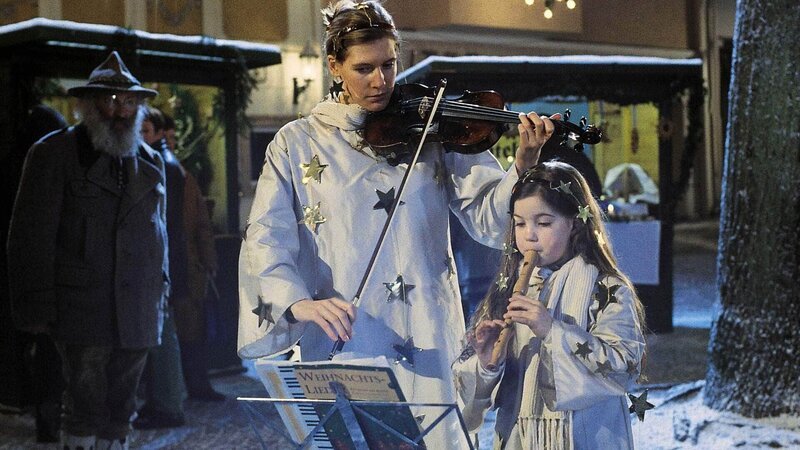 Susi (Ina Weisse) und ihre Tochter Katrinchen (Stefanie Werner) musizieren auf dem Weihnachtsmarkt, damit etwas Geld in die Haushaltskasse kommt. – Bild: RTL /​ Manfred Lämmerer