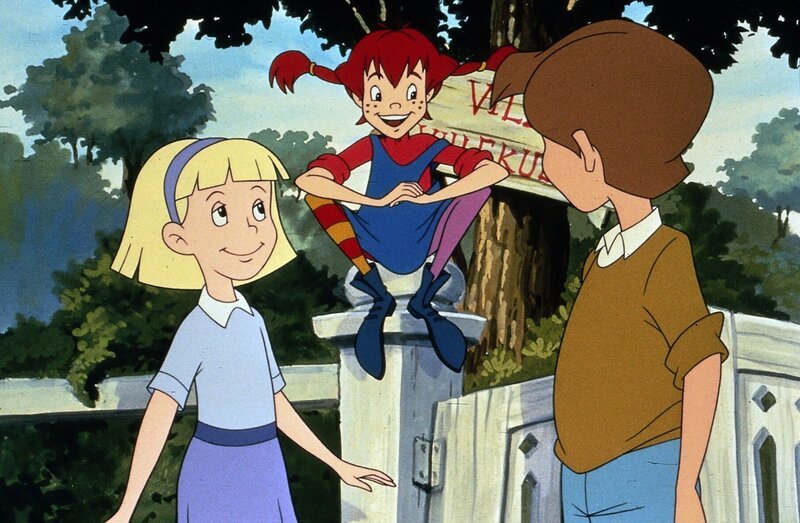 Pippi (Mi.) sitzt auf dem Zaun der Villa Kunterbunt und erzählt ihren neuen Nachbarn Tommy (re.) und Annika (li.) spannende Geschichten. – Bild: ZDF