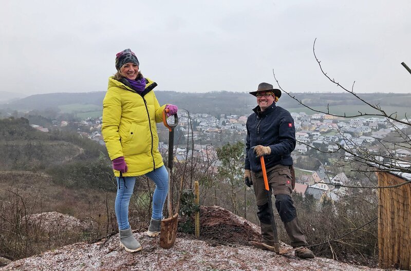 Anna Lena Dörr pflanzt in einem Arboretum mit dem Baumgarten-Ranger eine Stechpalme, den Baum des Jahres 2021. – Bild: SWR/​Heidrun Wieser