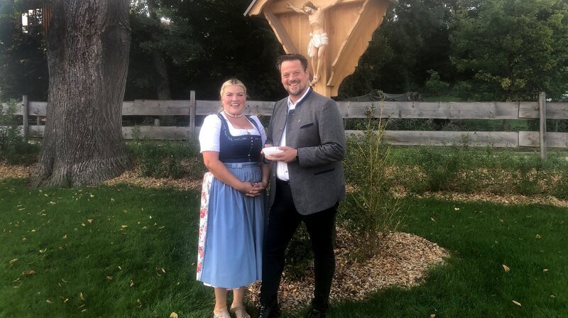 Auf dem Gschwandtnerhof am Tegernsee hat sich bei Landwirtin Nina Bartl hoher Besuch angekündigt: Der Pfarrer ist gekommen, um das neue Feldkreuz zu weihen. – Bild: NDR/​BR/​isarflimmern/​Tanja v.Ungern-Sternberg