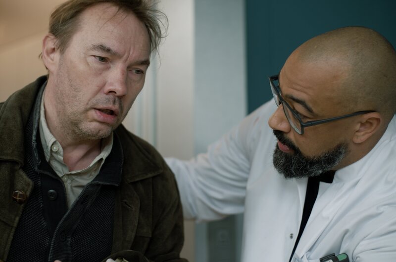 Dr. Evans (Tino Führer, r.) kümmert sich um Paul Dreyer (Thomas Arnold, l.), der offensichtlich auch bei dem Unfall in einem Straßencafé schwer verletzt wurde. – Bild: Jochen Braune /​ ZDF