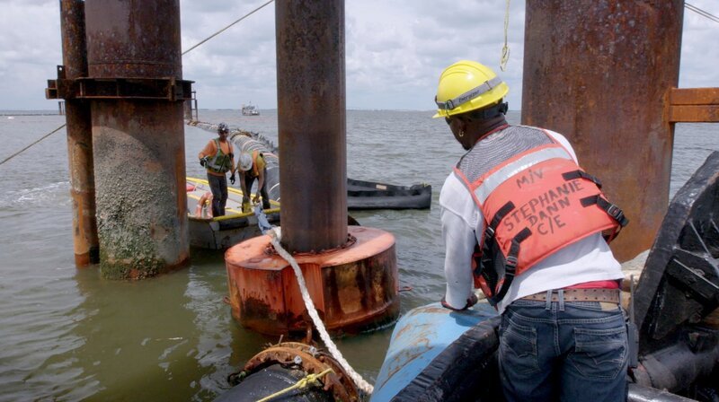 Bei Bergungsarbeiten muss die Umwelt gesichert und geschont werden. Dafür legen die Arbeiter ein Schutznetz aus. – Bild: Phoenix/​ZDF/​Renowned Films Limite
