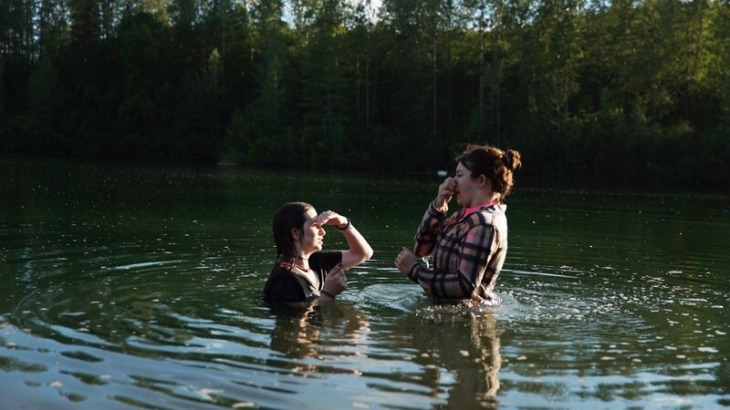 Bird Brown and Rain Brown have returned to Alaska and have fun swimming in a lake they used to swim in as young children. – Bild: Discovery Channel /​ Discover Images. /​ Warner Bros. Discovery, Inc. or its subsidiaries and affiliates. All rights reserved.