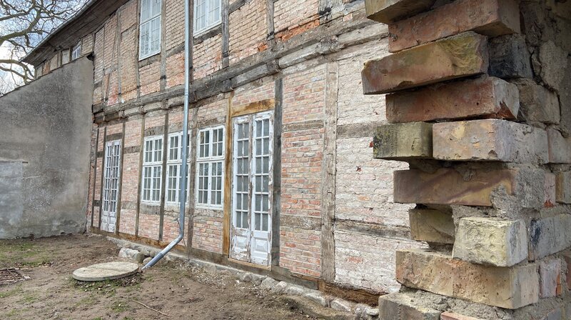 Nach drei Wochen strammer Arbeit ist die Fachwerkwand wieder hergestellt. Inklusive Feldsteinfundament. – Bild: NDR/​Populärfilm