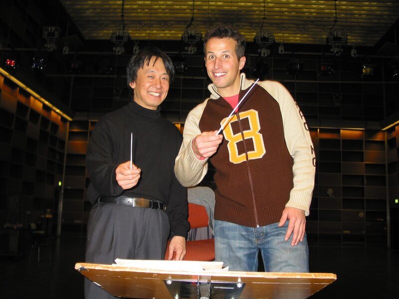 Willi Weitzel mit dem Dirigenten Toshiyuki Kamioka. Hier platzt Willi mitten in die Probe des Münchner Rundfunkorchesters im BR-Funkhaus. – Bild: Bayerischer Rundfunk /​ megaherz