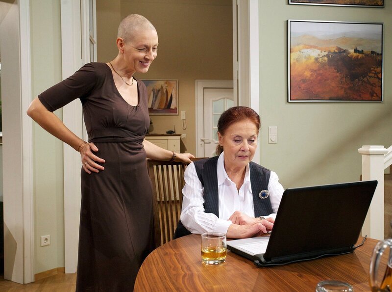 Charlotte Gaus (Ursula Karusseit) überzeugt Pia (Hendrikje Fitz) eine Perücke zu tragen; mit Hilfe eines Computerprogramms sehen sie andere Frisuren. – Bild: MDR/​Wernicke