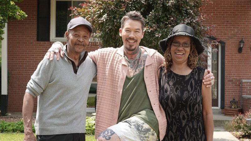 FROM LEFT TO RIGHT: MICHAEL O’HARA, HOST DAVID BROMSTAD, AND MIA O’HARA POSE FOR A PICTURE OUTSIDE OF HOUSE 2, TITMOUSE TRAIL, HERO – Bild: HGTV US /​ Warner Bros. Discovery, Inc. or its subsidiaries and affiliates.