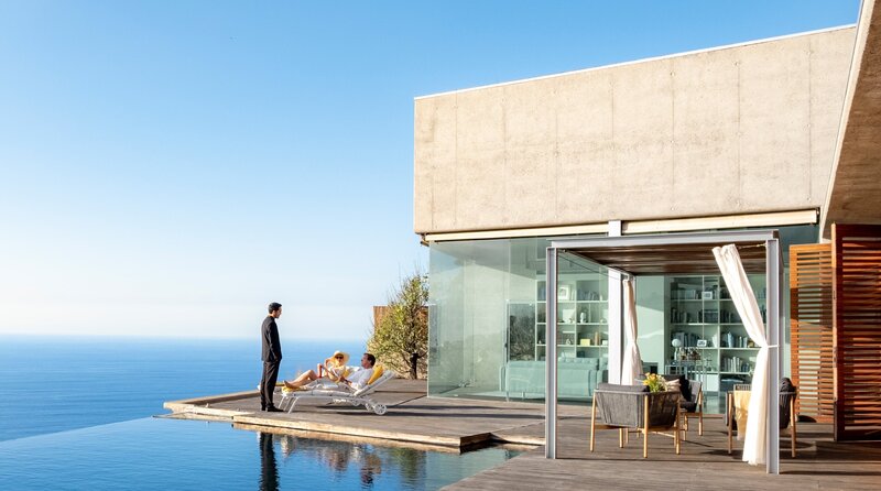 Bajrush (Alejandro Barrios) bei Jojo (Andrea Osvárt) und Allmen (Heino Ferch) auf Terrasse. – Bild: ORF/​Beta Film/​ARD Degeto/​PABLO MELIAN