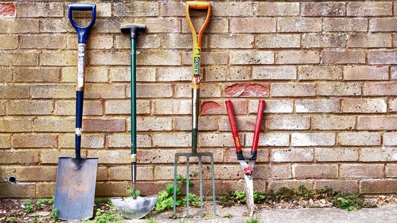 A Spade, edging tool, fork and some shears leaning against a garden wall made of bricks. – Bild: Discovery Science I