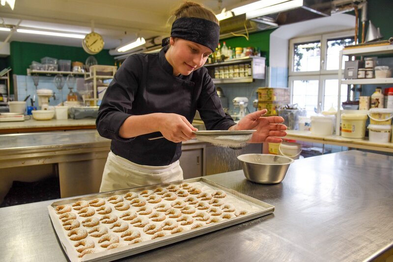 Simone Steidl zuckert ihre Vanillekipferl, die frisch aus dem Ofen sind. – Bild: ORF/​Produktion West/​Gerhard Mader