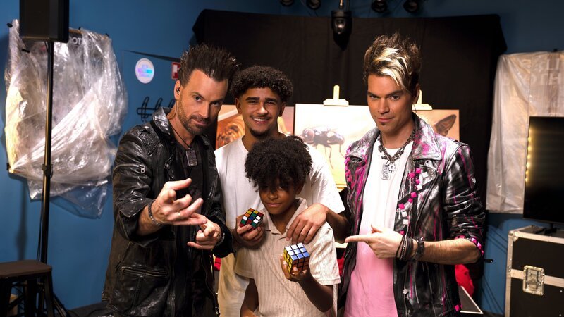 Liam (2.v.r.) hat es seinem großen Bruder Danyal (2.v.l.) heimgezahlt und zusammen mit den Ehrlich Brothers (Andreas, l. und Chris, r.) einen tollen Prank auf die Beine gestellt. Während er als Genie glänzt, verzweifelt sein Bruder an den Aufgaben einer ganz besonderen Marktforschung. – Bild: ZDF und André Goerschel