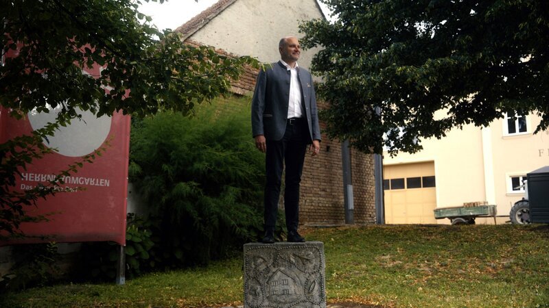 Bürgermeister Christian Frank waren zweisprachige Ortstafeln schon immer zu wenig: Seitdem gibt’s ihn Herrnbaumgarten zehnsprachige Ortstafeln! – Bild: ORF/​Familie Rockt Media