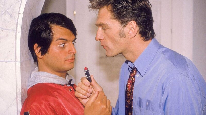 Schmidt (Walter Sittler, r.) bietet dem indischen Essenlieferanten Ranjid (Kaya Yanar) Geld, damit dieser sich Lippenstift aufträgt und ihn damit küsst, um so Nikola vorzuspielen, er hätte Damenbesuch. – Bild: MG RTL D
