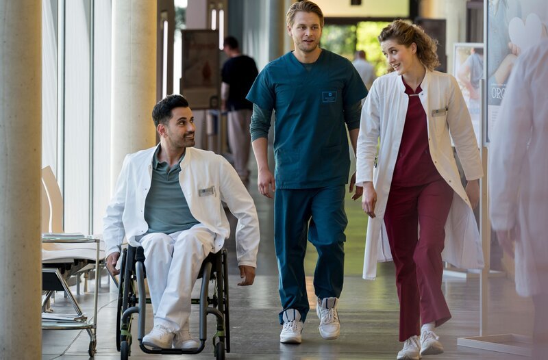 Dr. Mikko Rantala (Luan Gummich, M.) fiebert einer spektakulären Prothesen-OP entgegen, die er mit Dr. Elly Winter (Juliane Fisch, r.) durchzuführen hofft. Auch Dr. Ilay Demir (Tan Caglar, l.) aus der Sachsenklinik ist eigens zu dieser seltenen Operation aus Leipzig an das Johannes-Thal-Klinikum nach Erfurt gekommen. – Bild: ARD/​Jens-Ulrich Koch