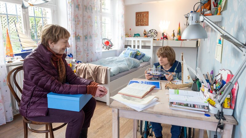 Der kleine Paul Beyer (Maximilian Brauer, r.) sitzt die meiste Zeit des Tages im Rollstuhl. Er hat nicht genug Kraft, um eigenständig zu laufen. Der Alltag für ihn und seine Mutter ist mühsam. Die beiden leben allein. Doch Paul vermisst seinen Vater.  Kann Rechtsmedizinerin Dr. Helene Sturbeck (Katharina Blaschke, l.) etwas aus dem Kleinen herauslocken? Kann Paul vielleicht helfen, den Täter zu finden? Hat sein Vater etwas mit dem Mord an der Sozialarbeiterin Rike Kröger zu tun? – Bild: ZDF und Meyerbroeker