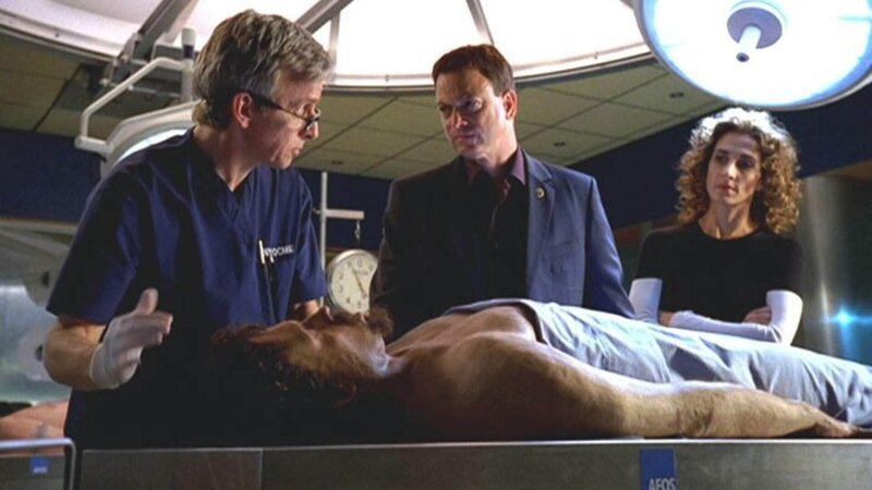 Neben einer männlichen Leiche haben Ermittler wertvolle antike Münzen gefunden. Dr. Hammerback (Robert Joy) erklärt den beiden Detectives Taylor (Gary Sinise) und Bonasera (Melina Kanakaredes), dass der Mann unter ähnlichen Umständen umkam wie ein Opfer, das Monate zuvor umgebracht worden war. – Bild: TVNOW, CBS