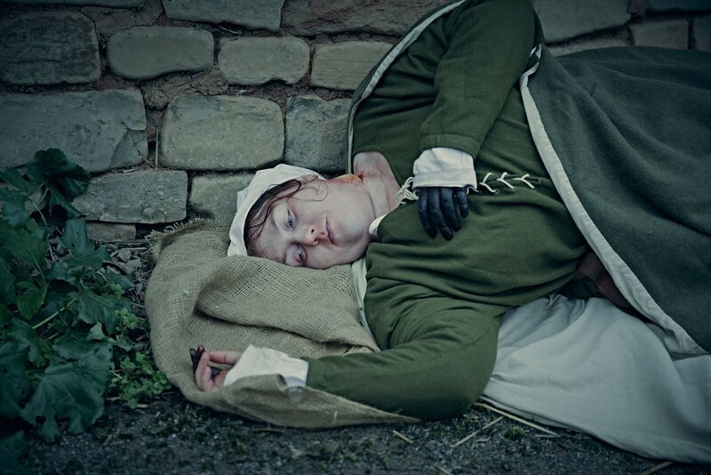 Eine Frau liegt in einem mittelalterlichen Kostüm – Bild: THE HISTORY CHANNEL