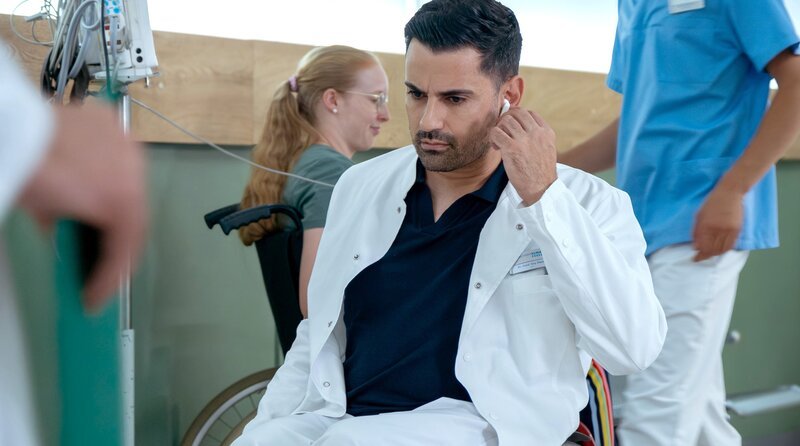 Dr. llay Demir (Tan Caglar) koordiniert den Abtransport der Patientinnen und Patienten in andere Kliniken. Doch es fehlt an genügend – Bild: MDR/​ Sebastian Kiss