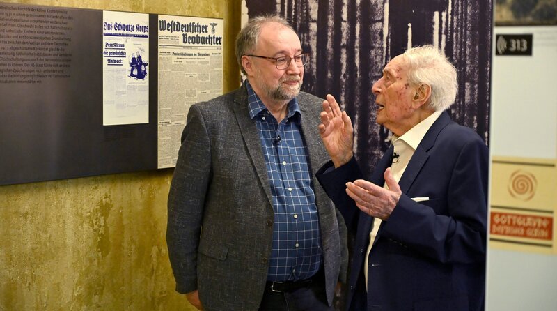 Dr. Martin Rüther (Historiker) und Ludwig Sebus (r) sprechen im NS-DOK über die katholische Jugendbewegung in der NS-Zeit. (Köln, 2025) – Bild: WDR/​Christoph Simon