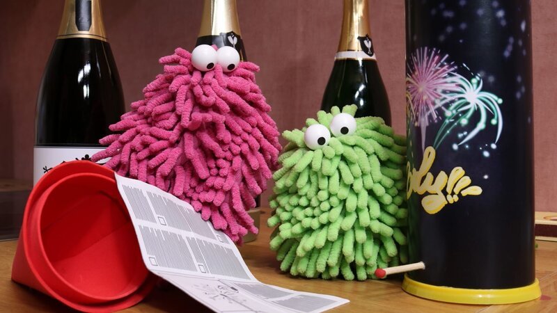 Wisch und Mop studieren aufmerksam die Anleitung für das Tischfeuerwerk. – Bild: NDR/​TRIKK17 GmbH & Co. KG