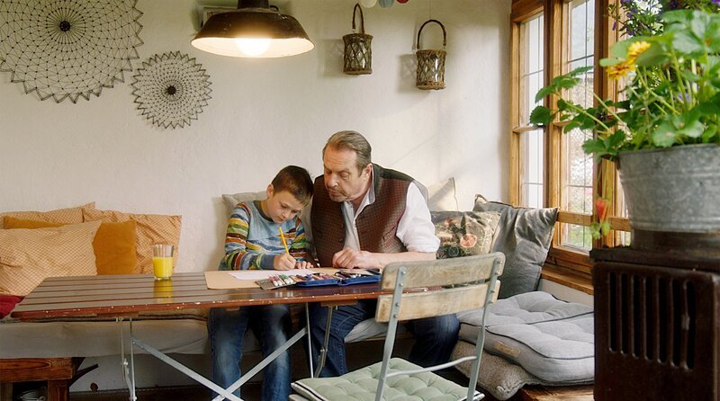 Luis Strasser (Thomas Walch, l.) erhält bei den Hausaufgaben die volle Aufmerksamkeit von Benedikt Beissl (Andreas Giebel, r.). – Bild: ARD /​ Lucky Bird Pictures /​ Luis Koppelkamm