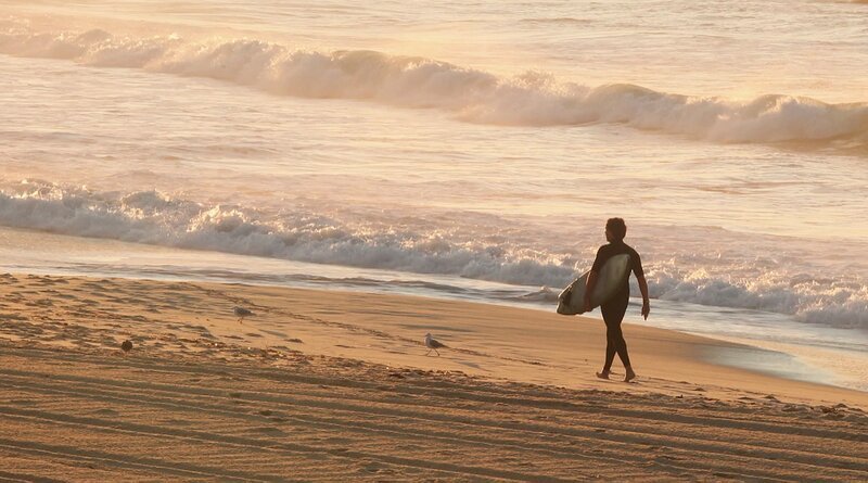 Einmal Sonne tanken. Wir sind unterwegs zu den schönsten Stränden der Welt. Von der Algarve bis zu den Seychellen – 20 Traumstrände, die Sie kennen sollten. – Surfer vor der Brandung. – Bild: rbb/​NDR /​ SWR Presse/​Bildkommunikation