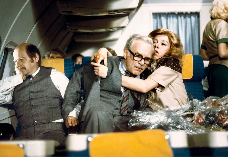 „Menschliche Nähe“ ist beim Fliegen geradezu unvermeidlich. Vor allem der Versuch, dem Mitreisenden beim Wechseln der Kleidung behilflich zu sein, kann zu Situationen führen, die unter normalen Bedingungen als nicht mehr korrekt bezeichnet würden (von links Heinz Meier,Loriot und Evelyn Hamann). – Bild: WDR/​Radio Bremen