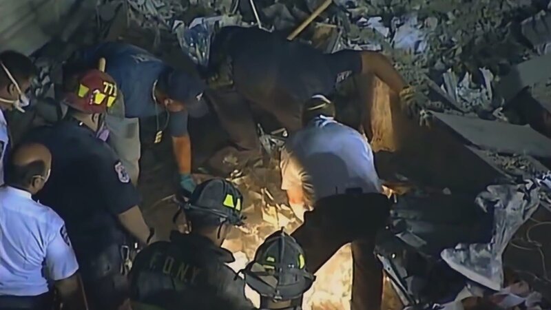 Rettungskräfte blicken in ein Loch in den Trümmern des Haufens. (Etienne Sauret) – Bild: Etienne Sauret