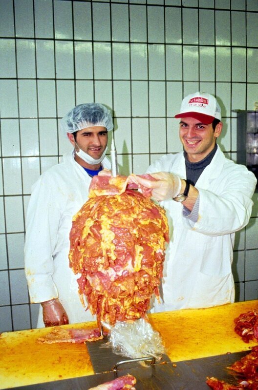 Wie werden eigentlich Döner-Spieße gemacht? Kaya Yanar (r.) besucht eine Döner-Fabrik und legt selbst mit Hand an. – Bild: SAT.1 /​ Guido Engels