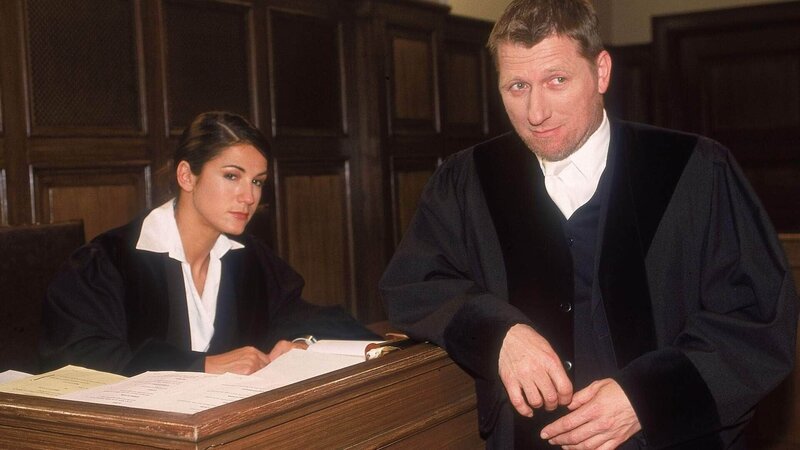 Die Staatsanwälte Sturm (Mariella Ahrens) und Brunner (Michael Fitz) verhören im Gerichtssaal gleich drei Frauen, die in Verdacht stehen Jochen Reitz ermordet zu haben. – Bild: MG RTL D /​ Rolf Baumgartner