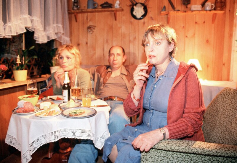 Erika Strunz (Katharina Thalbach, re.) sieht zusammen mit ihren Garten-Nachbarn Reinhard (Manfred Möck) und Uschi Paschke (Ingeborg Westphal) ihren Mann im Fernsehen. – Bild: „ARD Degeto/​Steffen Junghans“