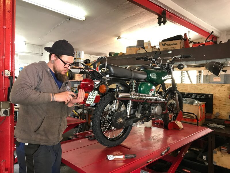 Workshop – mechanic fixing the damaged bulb headlight on the motorbike. – Bild: Spiegl TV Wissen