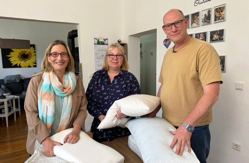 Auf den sozialen Medien bekommt man ständig Kaufempfehlungen für die verschiedensten Kissen, die erholsamen Schlaf und keine Rückenschmerzen mehr versprechen. Doch was können sie wirklich? Yvonne Willicks (l) holt sich Hilfe bei Michaela (M) und Olaf Hanke (r), die die verschiedenen Kissen Probeschlafen. – Bild: WDR/​Solis tv