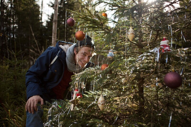 Checker Tobi hinter einem Christbaum. – Bild: BR/​megaherz gmbh/​Hans-Florian Hopfner