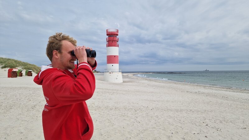 Rettungsschwimmer Nils ist für die Sicherheit auf der Badegäste auf der Düne zuständig. – Bild: TVN /​ ZDF