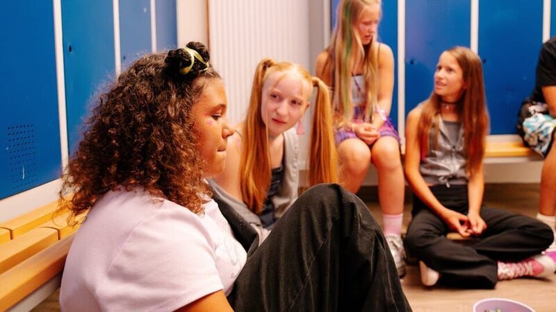 Bei einem Party-Spiel zieht Samira (Soumayah Özel, links) die rote Kugel. Sie soll Riccardo küssen. – Bild: ZDF/​ Justus Lemm