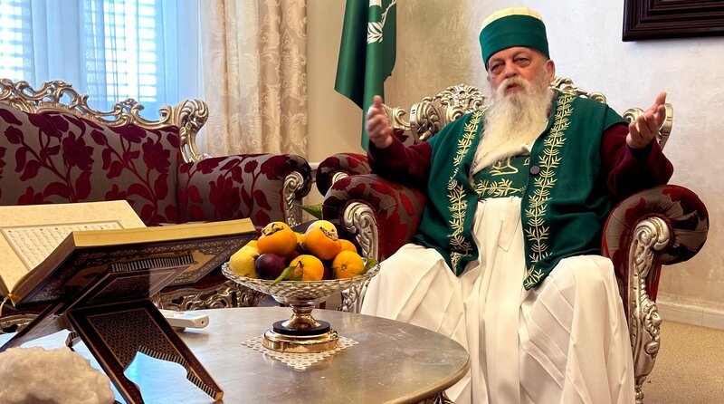 MDR FERNSEHEN HEUTE IM OSTEN – REPORTAGE, „Entsteht Albaniens muslimischer Mini-Staat?“, am Samstag (12.04.25) um 18:00 Uhr. Ab 11.04.2025, 08:00 Uhr in der ARD-Mediathek. Baba Mondi im Empfangszimmer des Bektaschi-Weltzentrums. In diesem Sessel des Empfangsraumes begrüßt Baba Mondi im Weltzentrum der Bektaschi sowohl Presseleute als auch offizielle Delegationen aus aller Welt, aber auch Bektaschi-Gläubige und -Anhänger, um bestimmte Rituale und Gebete durchzuführen. – Bild: MDR/​Paul Tutsek