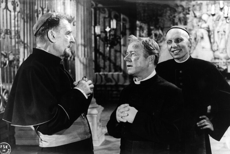 Der Bischof (Rudolf Forster, links) hat Pater Brown (Heinz Rühmann, Mitte) wieder einmal nach Dublin zitiert, um ihm gehörig den Kopf zu waschen. Er wünscht, daß ein für allemal Schluß ist mit der Detektiv-Spielerei! Koadjutor Malone (O. E. Fuhrmann) beobachtet die Situation mit gewisser Schadenfreude. – Bild: BR/​ARD-Filmredaktion