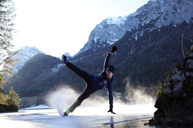 In einer Mischung aus Akrobatik und Breakdance gleitet Patrick Brunold über die zugefrorene Eisfläche des Hintersees. – Bild: Patrick Brunold /​ BR