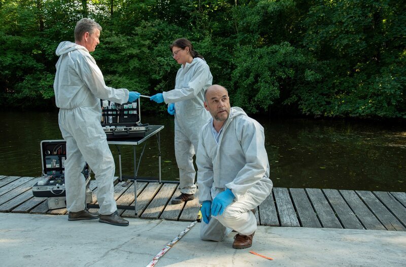 Dr. Henning Strahl (Christoph Tomanek, r. mit Komparsen, h.) macht eine interessante Entdeckung: Der Fundort ist nicht der Tatort! – Bild: ARD/​Thorsten Jander
