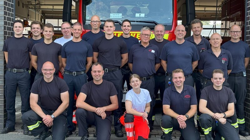 Firefighters in front of the fire truck in Bielefeld. – Bild: Warner Bros. Discovery, Inc. or its subsidiaries and affiliates