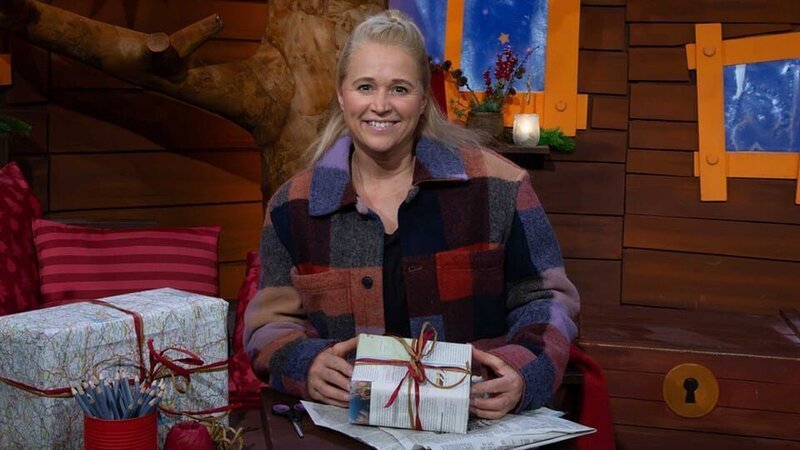 Singa packt Weihnachtsgeschenke ein. Dafür möchte sie einen Geschenkanhänger basteln. Als sie vom Fernrohr kommt, haben die Wichtel ihn schon fertig gebastelt. – Bild: KiKA
